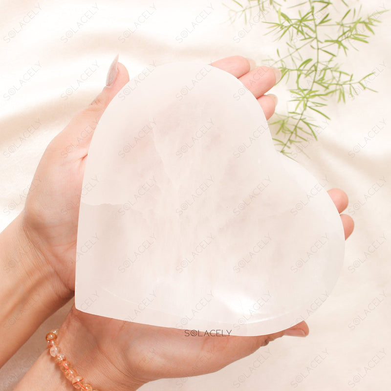 Heart-shaped selenite crystal held in hands