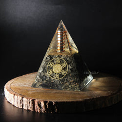 Pyrite Orgone Pyramid on round wooden base with black background