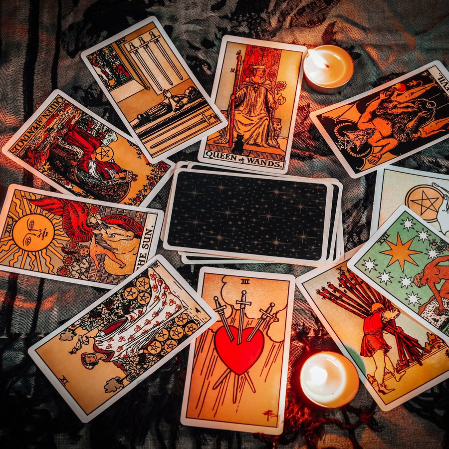 Tarot cards with candles on fabric background