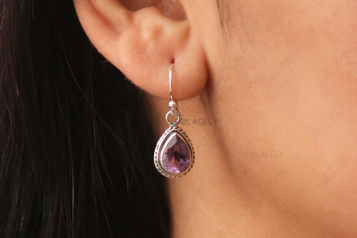 Crystal drop earring worn on the ear in warm daylight