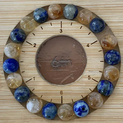 Blue gemstone bracelet resting on a wooden charging wheel