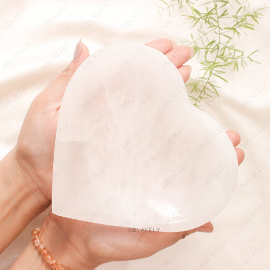 Heart-shaped selenite crystal held in hands