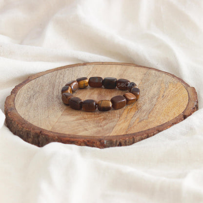 Tiger's Eye Tumble Bracelet on wooden base