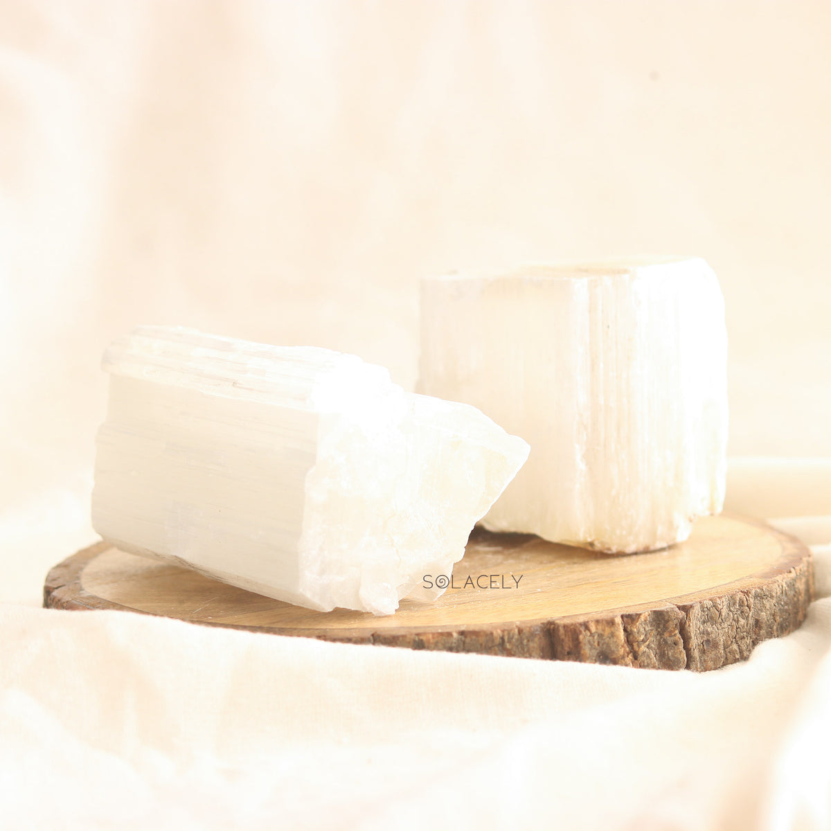 Two Selenite stones on wood slice
