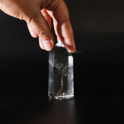 Hand holding a clear quartz crystal point