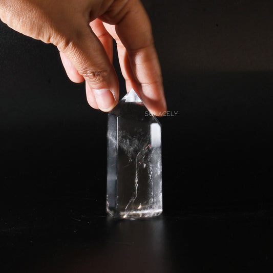 Hand holding a clear quartz crystal point