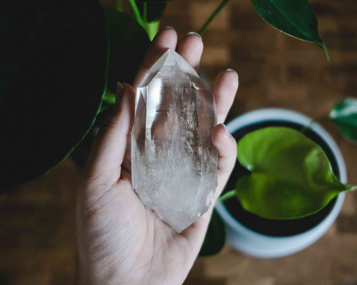 Natural clear quartz cluster, raw growth points catching daylight