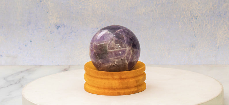 Amethyst crystal sphere on a wooden stand