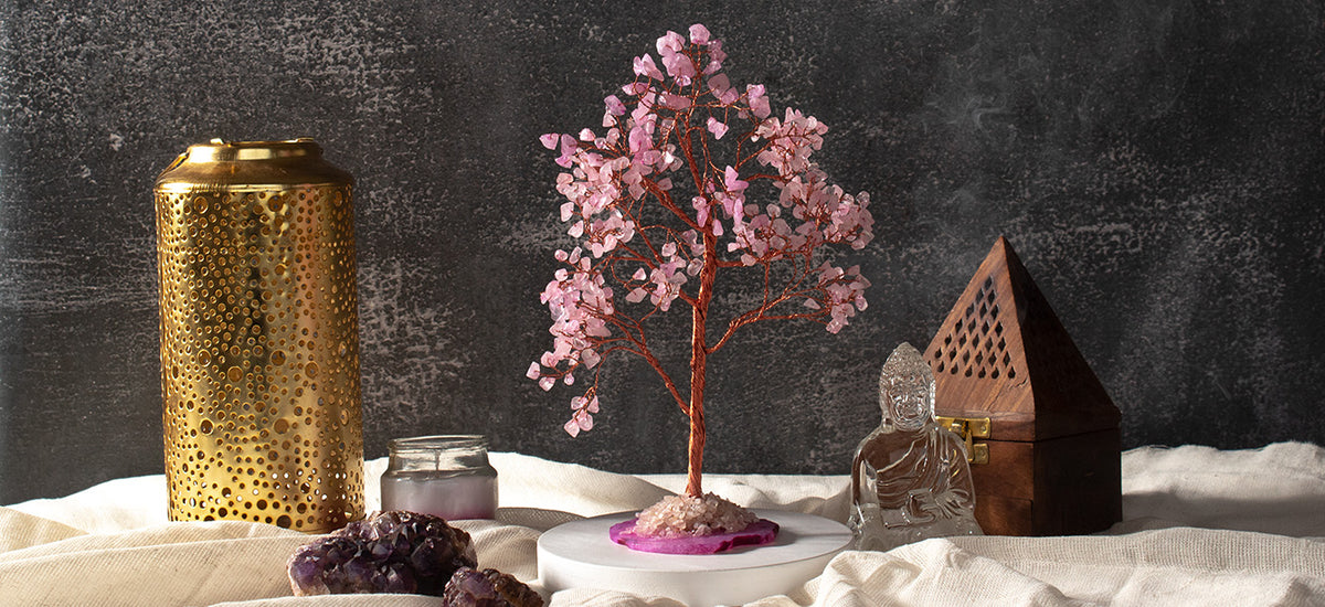 Rose quartz crystal tree styled with a brass lantern, amethyst geode and Buddha figure