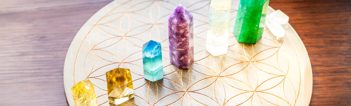Crystal towers arranged on a wooden flower of life plate, styling a surface