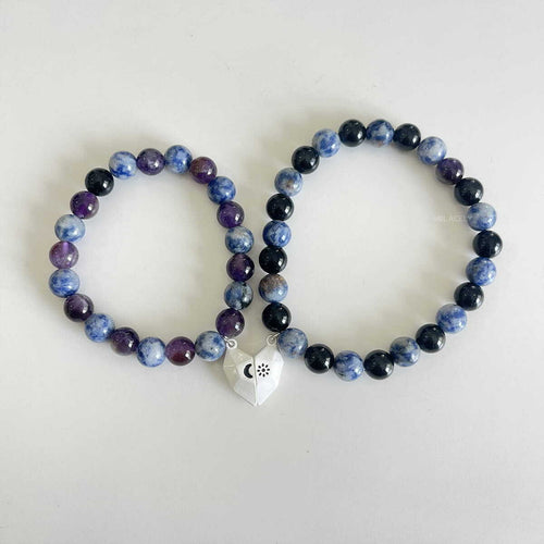 Matching blue and purple beaded bracelets with a gold charm
