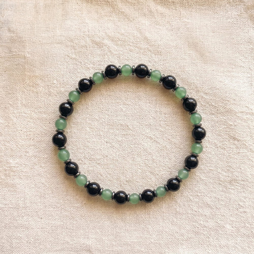 Green gemstone bracelet held in a hand