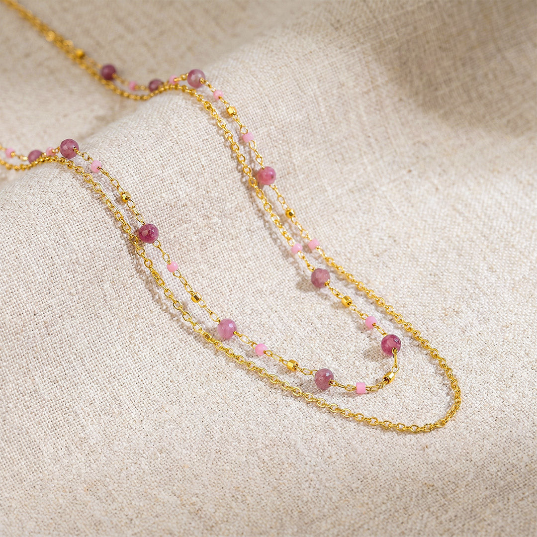 Pink tourmaline layered chain necklace flatlay on natural linen