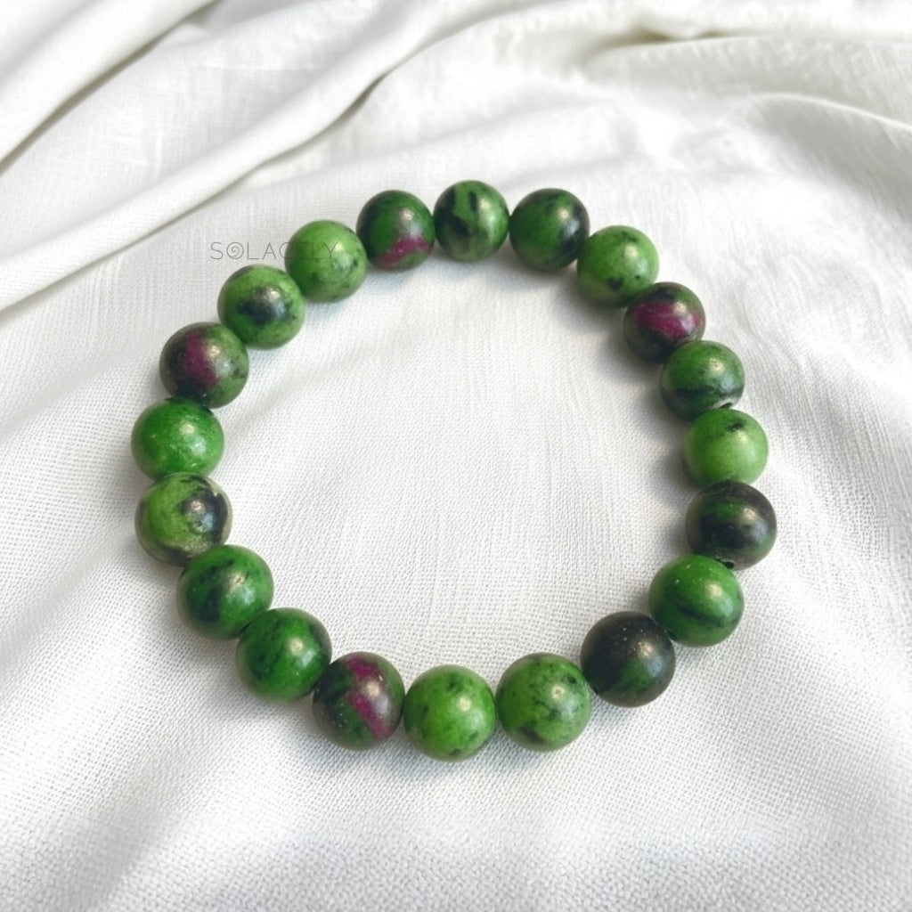 Ruby zoisite bead bracelet on cream linen, green stone with pink ruby patches