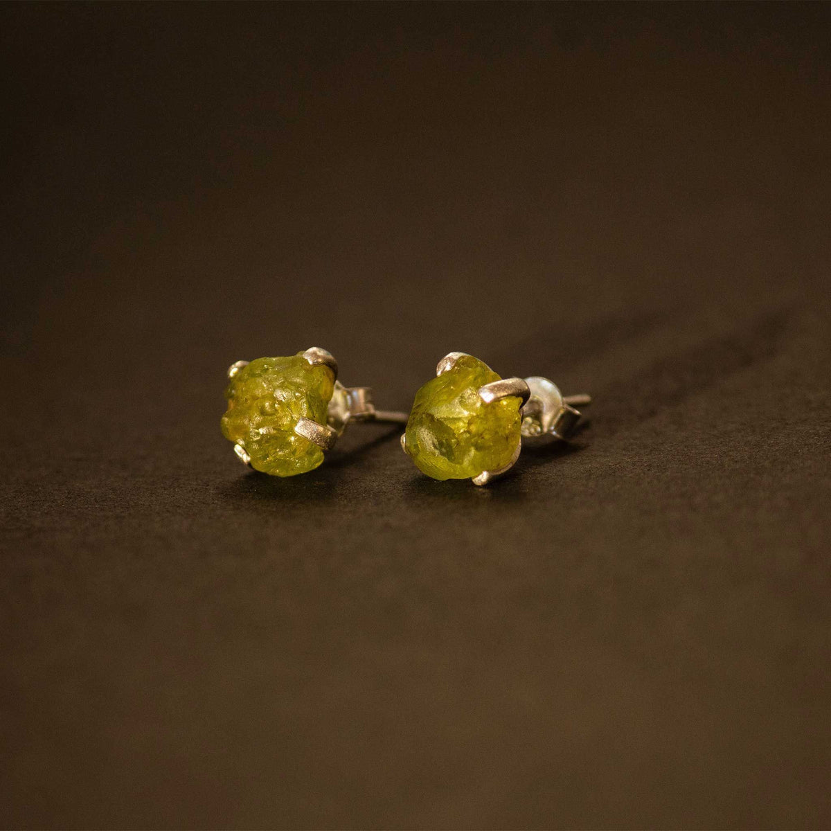 silver earrings with raw peridot